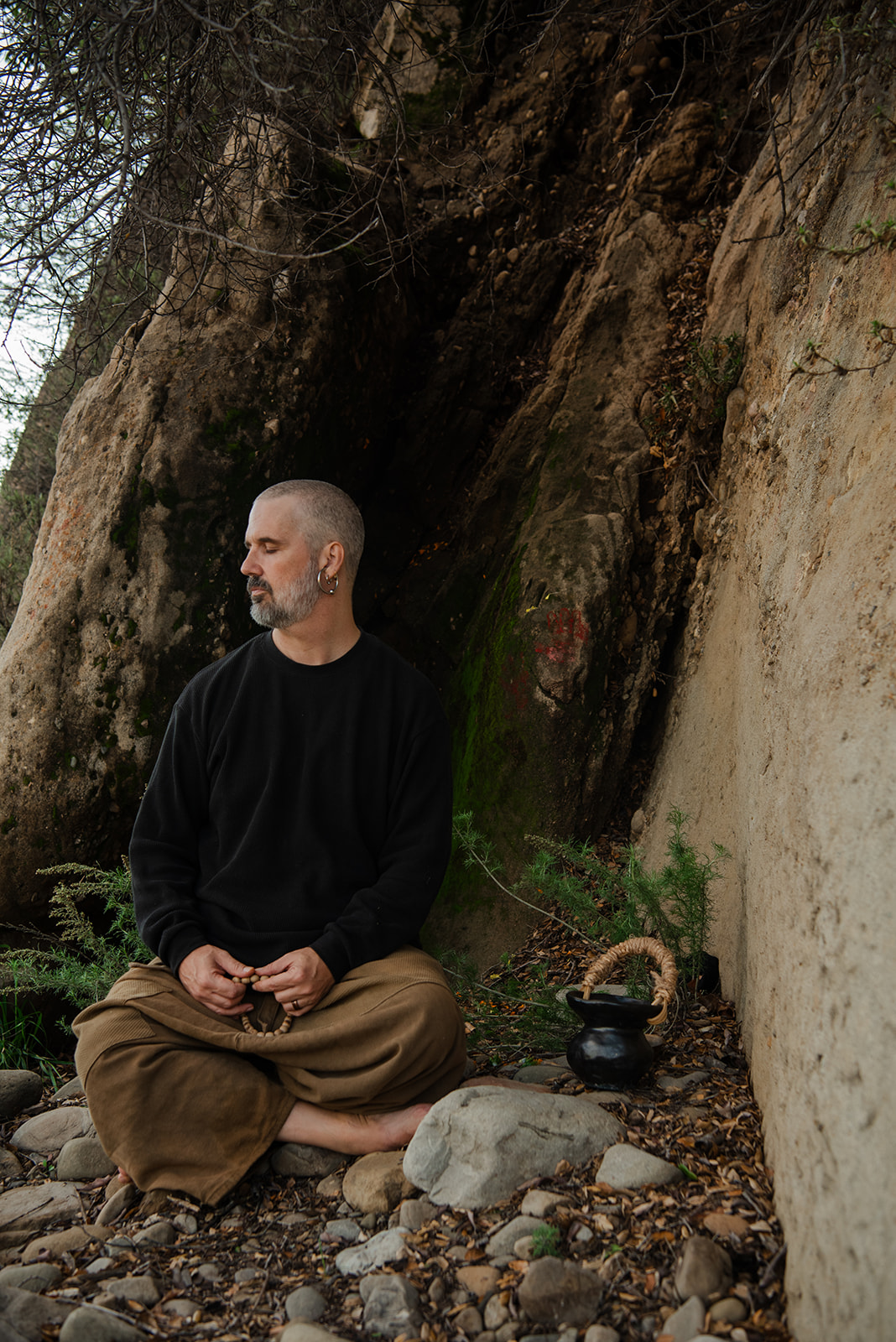 Harshada Wagner seated in meditation in a natural rock alcove