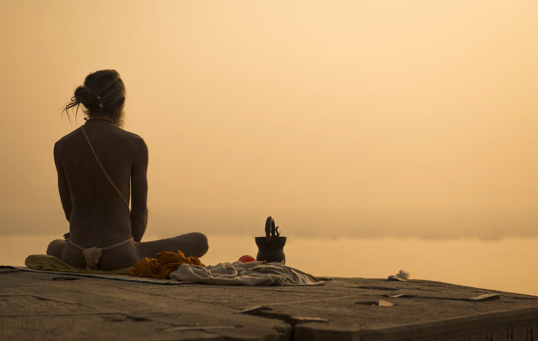 A person seated in meditation beside the sea