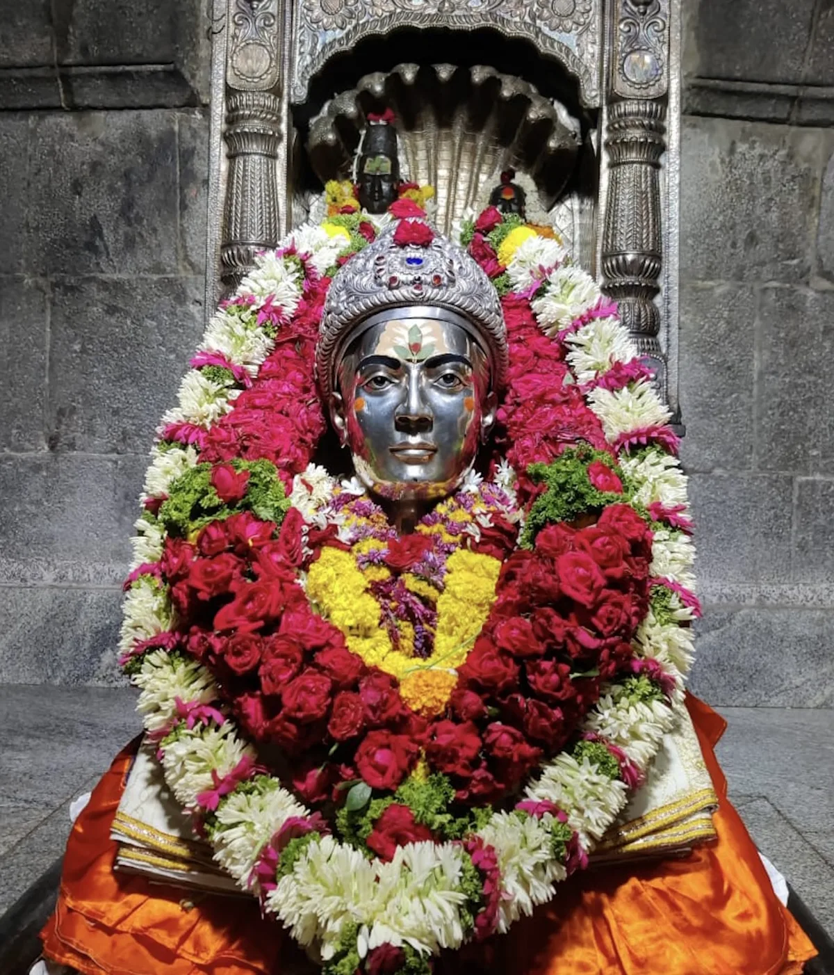 A flower-adorned deity shrine in a stone temple